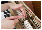 ピアノのハンマーに紙やすりをかけているところ